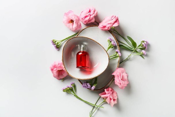 Složení s lahví květinového parfému na světlém pozadí - Fotografie, Obrázek