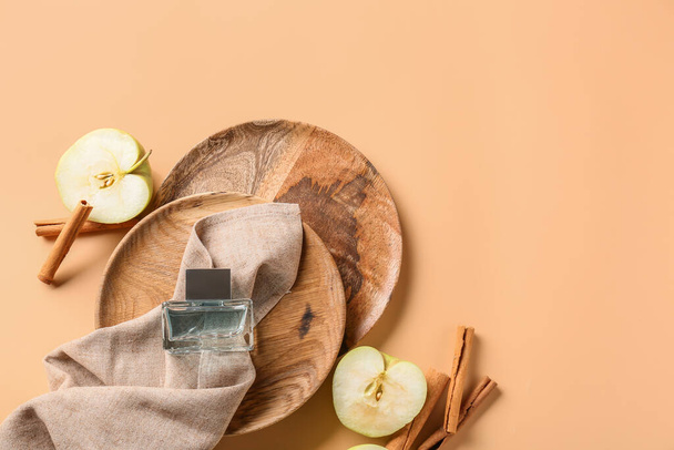 Composición con frasco de perfume, manzanas y canela sobre fondo claro - Foto, Imagen