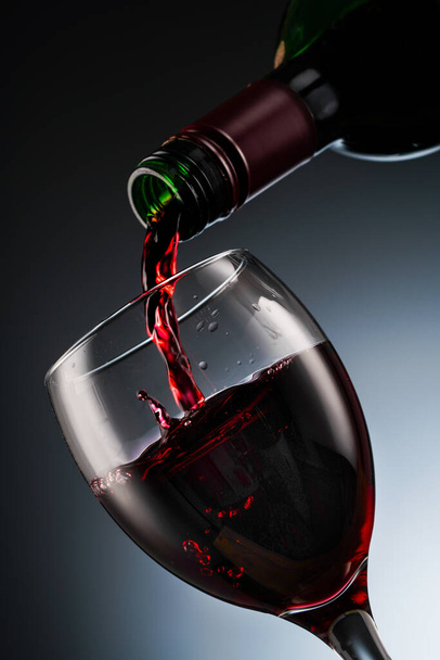Sklenice červeného vína a lahve - Fotografie, Obrázek