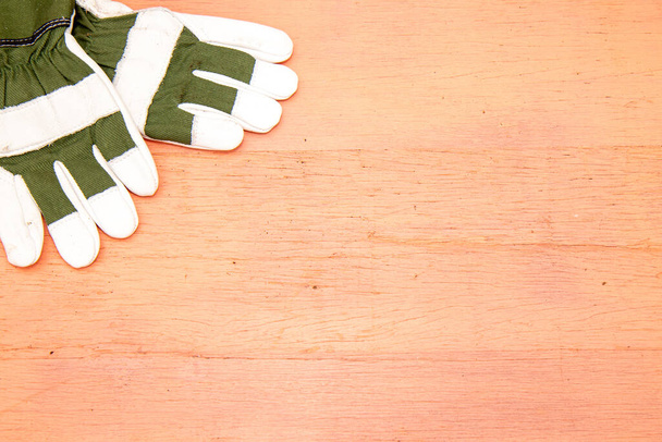 Dvojice zelených a bílých zahradnických rukavic na růžovém obrázku - Fotografie, Obrázek