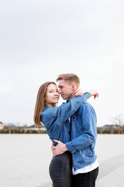 Happy young loving couple embracing each other outdoors in the park having fun - 写真・画像