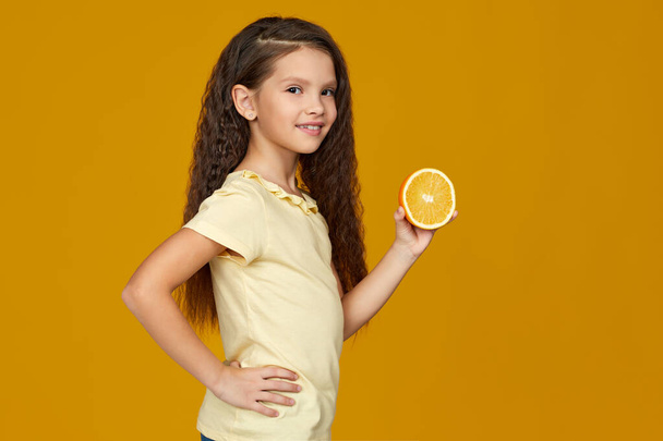 little child girl holding fresh juicy orange - Foto, imagen