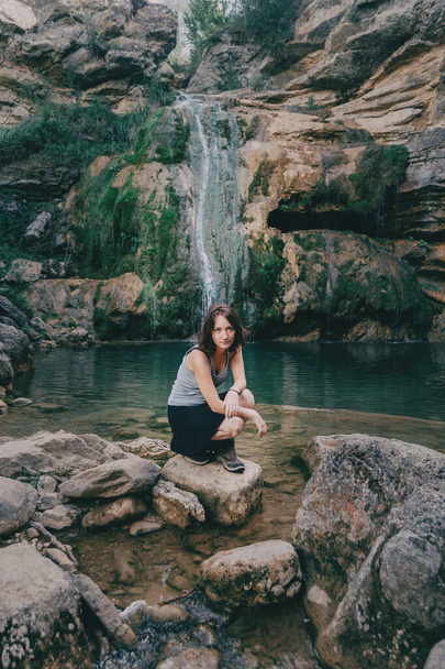 woman next to a waterfall looking at camera - Photo, Image