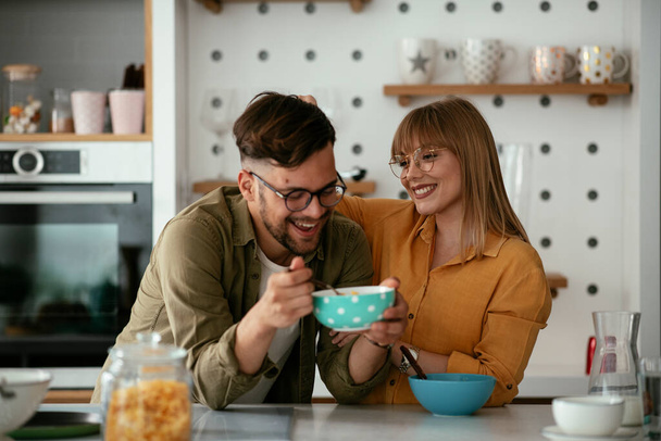Giovane coppia che prepara la colazione a casa. Coppia amorevole mangiare cereali in cucina. - Foto, immagini