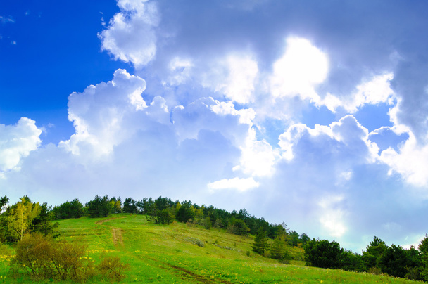 Fantástico céu nublado sobre a floresta e colina
 - Foto, Imagem