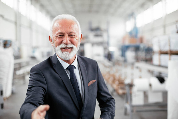 Portrait of handsome senior businessman. Man handshake in factory. - Foto, Imagen