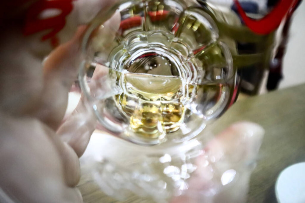 абстрактне зображення руки тримає келих пива, вид зверху на скляне дно екстремально крупним планом
  - Фото, зображення