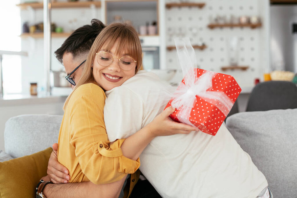 Man surprising his girlfriend with a gift. - 写真・画像