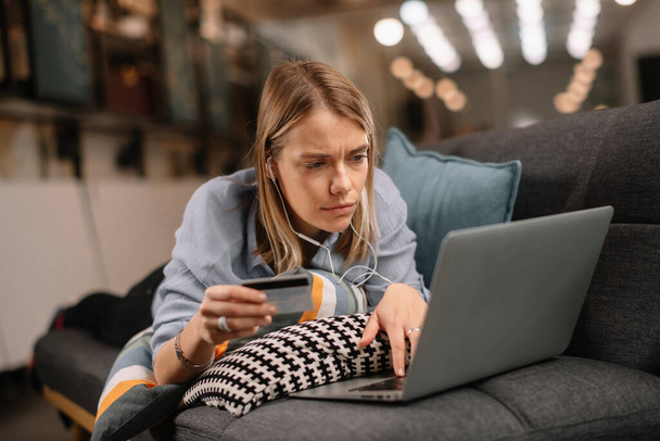 Young woman holding credit card and using laptop computer. Online shopping concept - Photo, Image