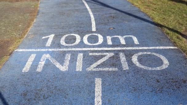 pista de carreras - escrito en el suelo al inicio de la carrera - concepto genérico de iniciar la actividad y alcanzar un objetivo establecido - 100 metros - Metraje, vídeo