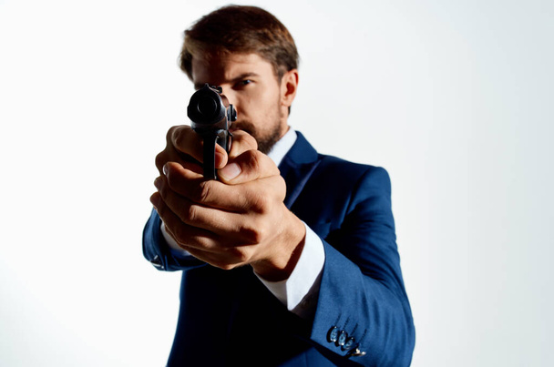 Mann im Anzug hält Waffe in der Hand - Foto, Bild