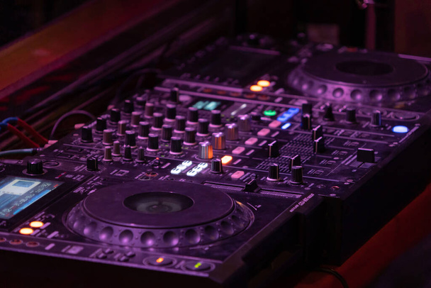 Mixes on CD players or track at nightclub during party for DJ. Nightlife of disco club in disco pub club bar background for party music dancing festival performance. Entertainment nightlife. - Foto, imagen