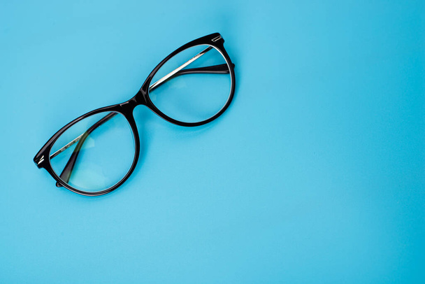 top view round black Eye Glasses on blue pastel Background - Photo, Image