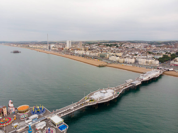 Ilmakuva kuuluisasta Brightonin laiturista ja valtamerestä, joka sijaitsee Englannin etelärannikolla Yhdistyneessä kuningaskunnassa, joka on osa Brightonin ja Hoven kaupunkia, joka on otettu kirkkaana aurinkoisena päivänä näyttämällä huvipuistolaitteita. - Valokuva, kuva