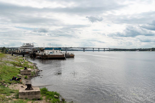 Russia  Kostroma  July 2020. Magnificent view of the Volga river with a bridge and a parking lot for motor ships. - Fotoğraf, Görsel