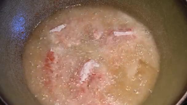 Home life scene: close-up footage of floured shrimps and squid rings being dipped in hot oil. Hot oil in contact with food immediately begins to fry. They are then turned with a fork. - Footage, Video