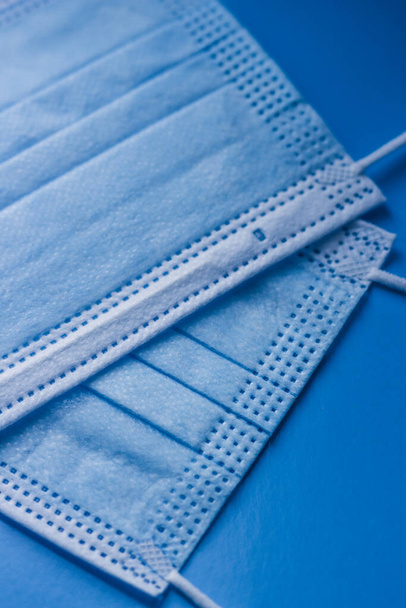 máscaras médicas protectoras de color azul primer plano sobre un fondo azul - Foto, Imagen
