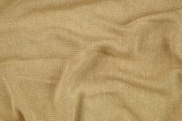 Beige delicate knit. A draped surface of clothing. - Photo, Image