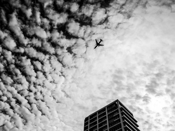 Airplane flying in the sky above the skyscraper. Tel-Aviv, Israel - Photo, image