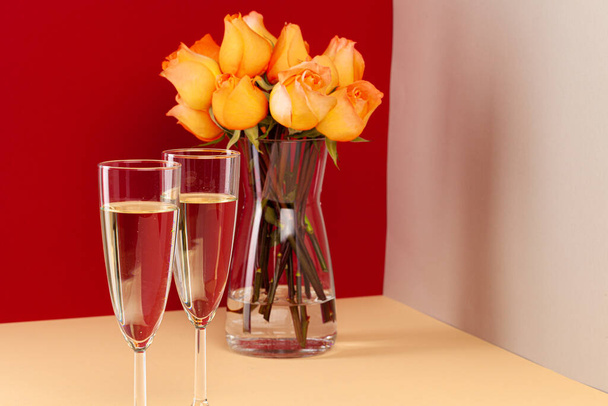 Close up photo of champagne glasses with roses in a vase - Foto, Bild