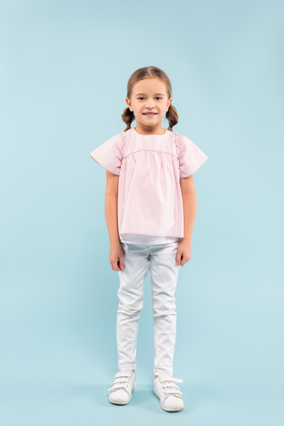 full length of cheerful child standing on blue - Photo, Image