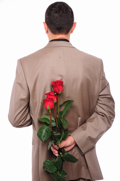 Young man hides behind a rose - Valokuva, kuva