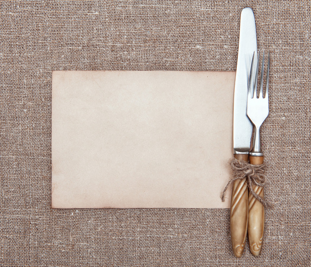 vork, mes en oud papier op de jute  - Foto, afbeelding