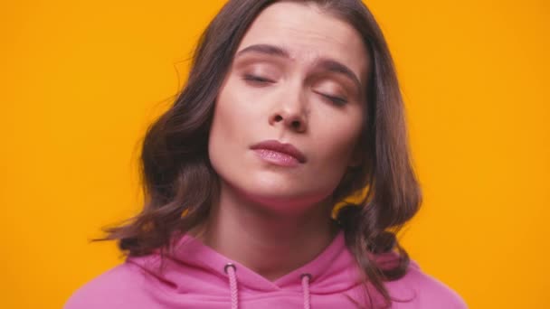 αναστατωμένη γυναίκα ξεφυσώντας μάγουλα απομονωμένα στο κίτρινο - Πλάνα, βίντεο