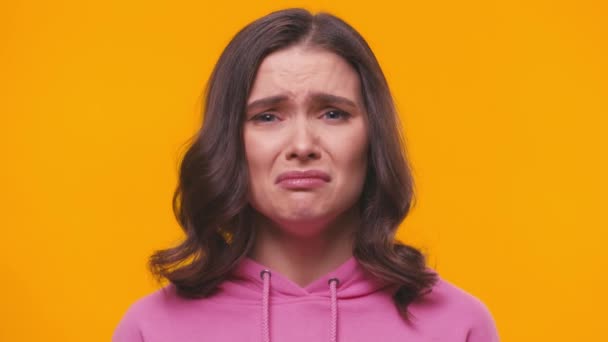 mujer molesta llorando mientras mira la cámara aislada en amarillo - Metraje, vídeo