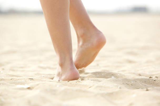 Femme marchant pieds nus sur le sable
 - Photo, image