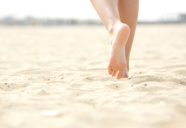 Frau läuft barfuß am Strand - Foto, Bild