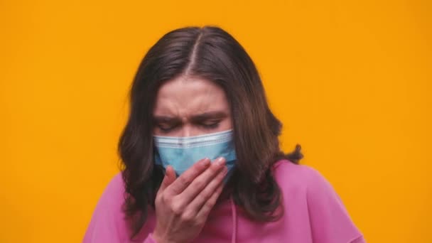 zieke vrouw met medisch masker hoesten geïsoleerd op geel - Video