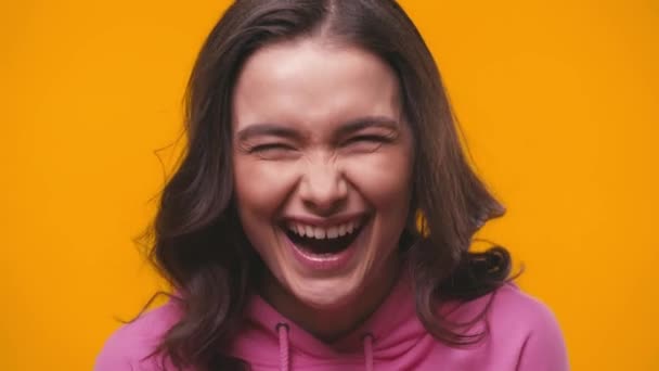 fröhliche junge Frau lacht vereinzelt auf gelb - Filmmaterial, Video
