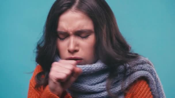 хвора брюнетка жінка в шарфі кашляє ізольована на синьому
 - Кадри, відео