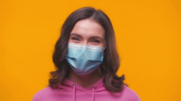 若いですブルネット女性で医療マスクで黄色に隔離された - 映像、動画