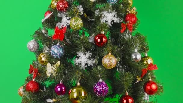 Auf grünem Hintergrund großer Weihnachtsbaum mit bunten Birnen geschmückt  - Filmmaterial, Video