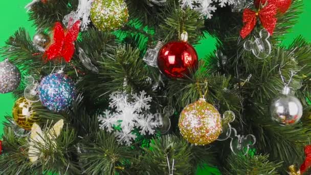 Auf grünem Hintergrund Weihnachtsbaum mit bunten Kugeln geschmückt  - Filmmaterial, Video