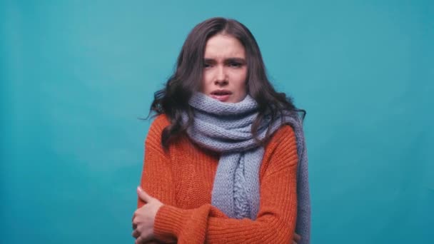mulher doente no cachecol congelamento e espirros isolados em azul - Filmagem, Vídeo
