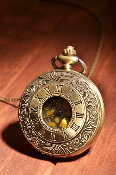 Relógio de bolso em fundo de madeira
 - Foto, Imagem