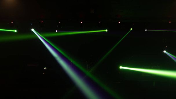パーティー音楽ダンスフェスティバルのパフォーマンスのためのディスコパブクラブバーの背景にカラフルな照明レーザービームスポットライトショーと空のステージコンサート。エンターテイメントナイトライフ。お祝い事. - 写真・画像