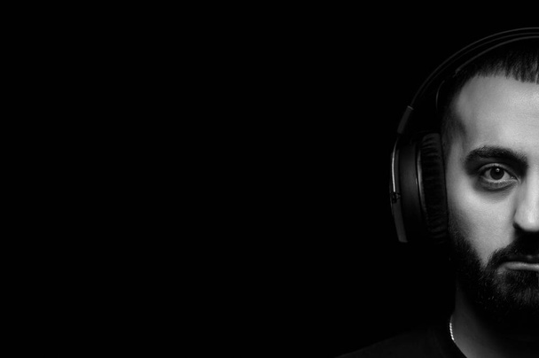 Czarno-biały portret brodatego mężczyzny słuchającego muzyki ze słuchawkami - Zdjęcie, obraz