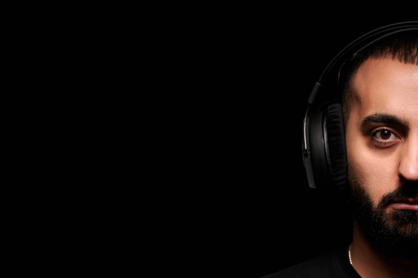 黒の背景にヘッドフォンで音楽家DJのクローズアップ肖像画 - 写真・画像