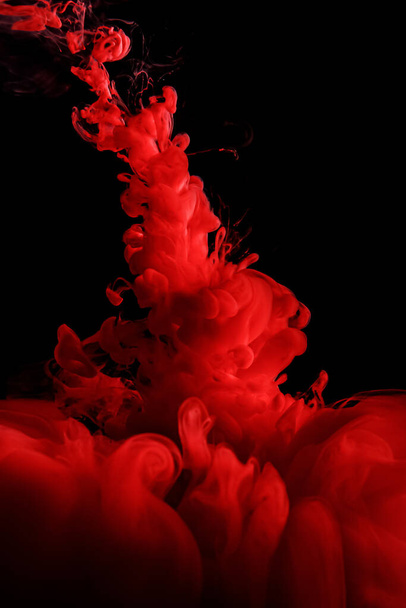 Red abstract background. Ink splashes in water on black - Photo, Image