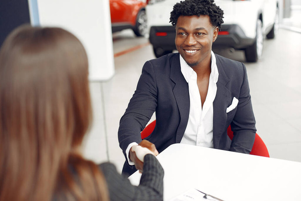 Handsome and elegant black man in a car salon - Foto, Imagem