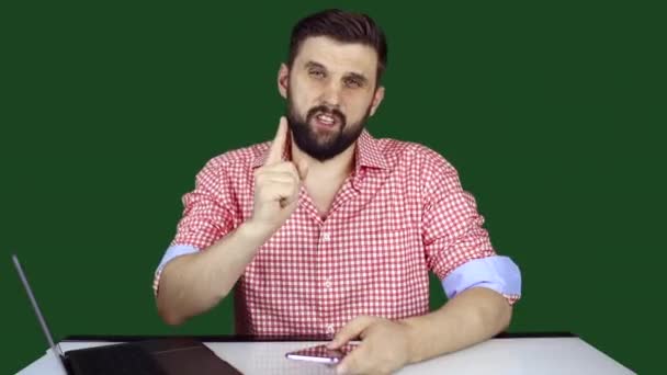 um blogueiro de tecnologia masculina fala sobre gadgets e gestos com as mãos no fundo de um chromakey - Filmagem, Vídeo