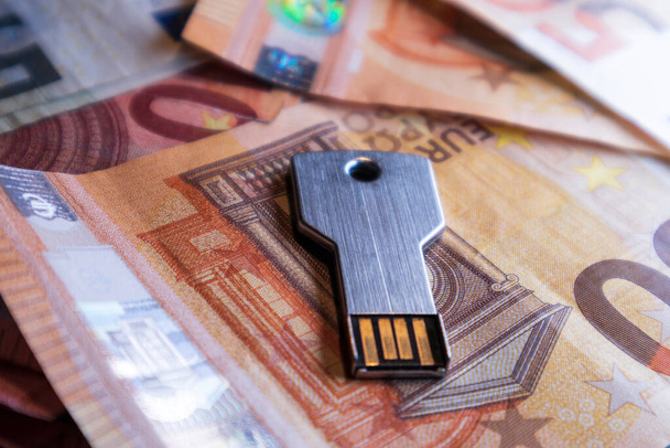 USB флэш-накопитель в виде ключа. Фон размытых банкнот евро - Фото, изображение