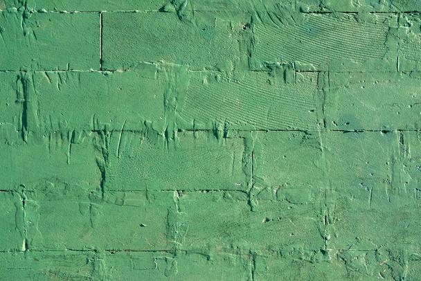 stará ošuntělá zelená zeď z velkých cihel. hrubá textura povrchu - Fotografie, Obrázek