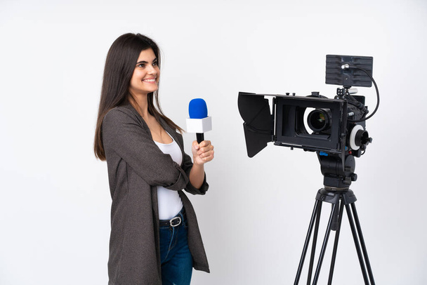 Reporter kobieta trzyma mikrofon i raportuje wiadomości na odizolowanym białym tle patrząc z boku - Zdjęcie, obraz