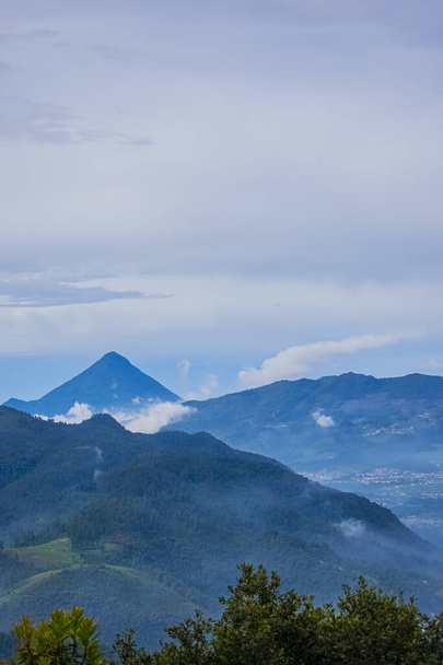volcan avec montagnes beau paysage avec nuages gris et forêt bleue - Photo, image