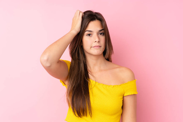 Teenager Brazilian girl over isolated pink background with an expression of frustration and not understanding - Photo, image